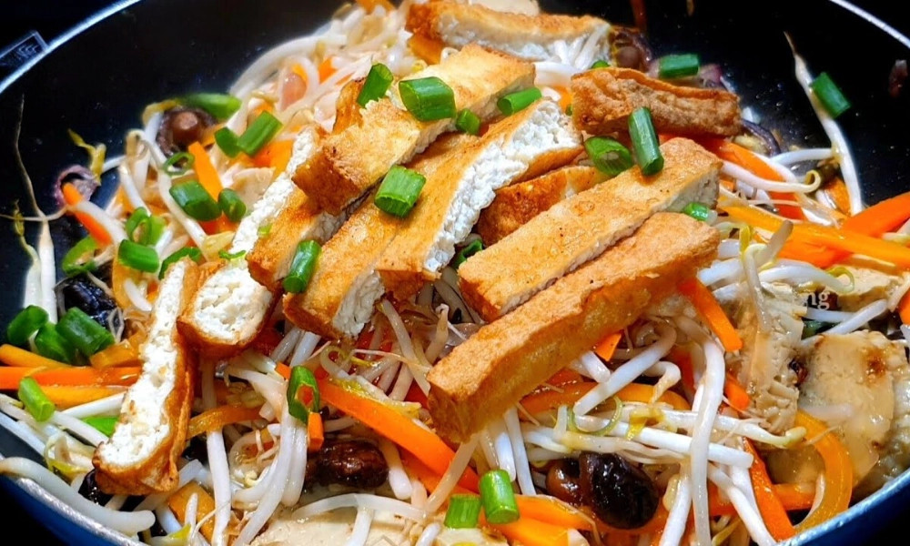 alt:  Đổ rau củ đã ướp gia vị vào chảo, đảo đều tay cho đến khi rau củ chín mềm và thấm gia vị.