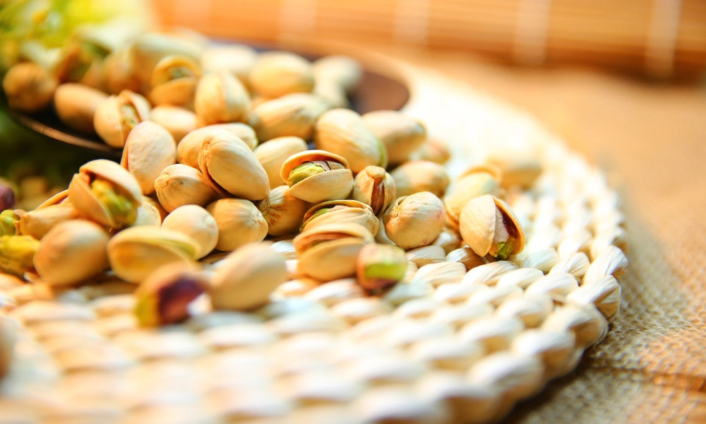 Alt: Ly sữa hạt dẻ cười yến mạch thơm ngon, bổ dưỡng được đặt trên bàn gỗ, bên cạnh là nguyên liệu làm sữa gồm hạt dẻ cười, yến mạch và một bình nước lọc.